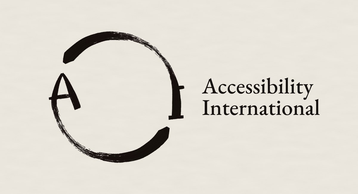 The Accessibility International logo: a black ink circle painted in two brushstrokes, open in two places, with a hand-brushed A on the left and a serif I on the right, beside the words Accessibility International in a classic serif, on warm off-white paper.